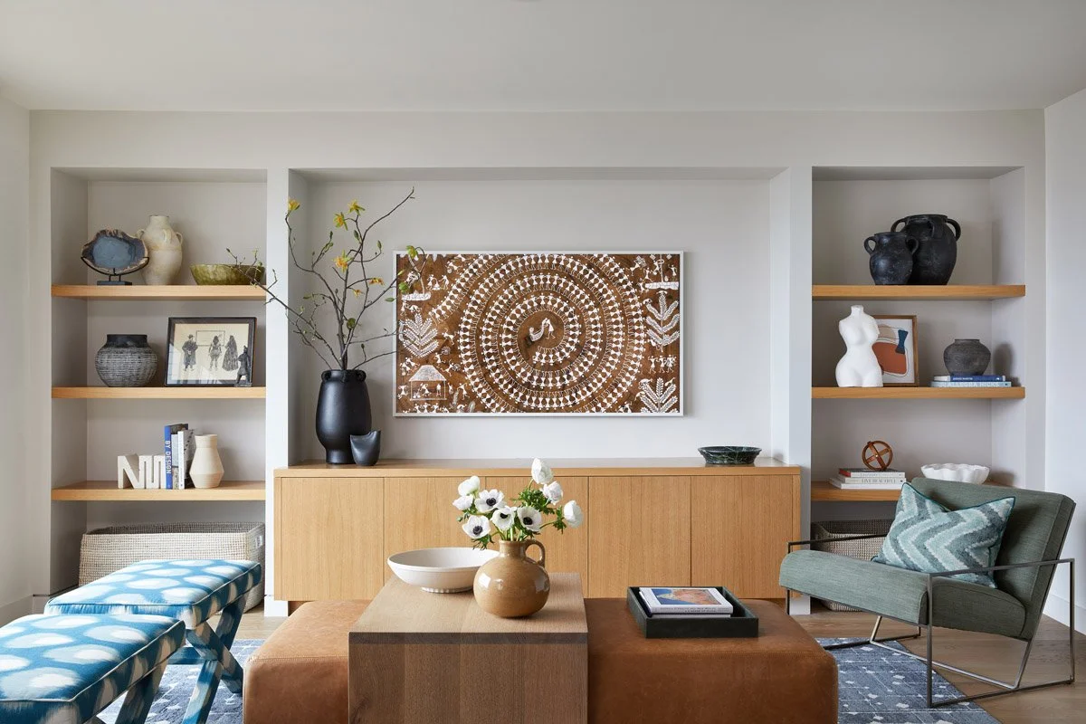 living room with built-in shelving, carved wood wall art and blue patterned benches