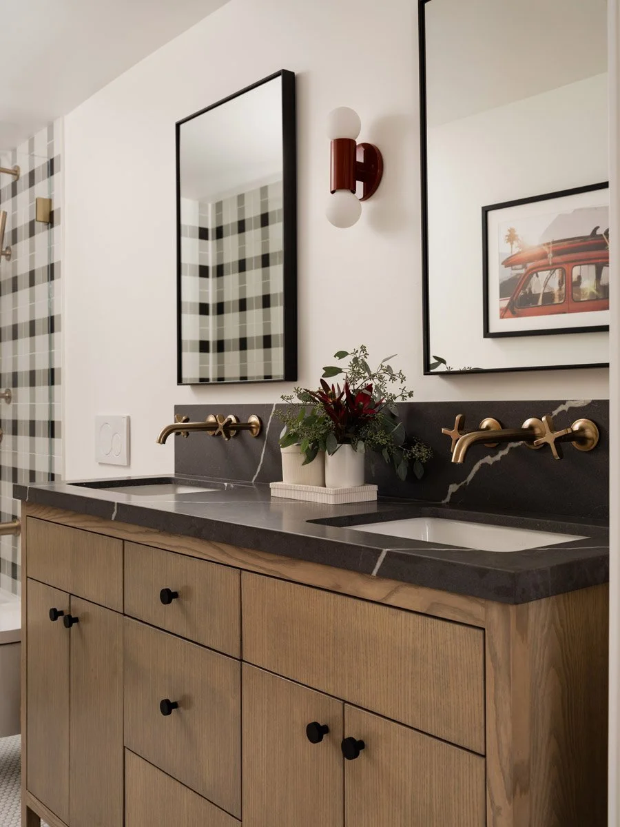 bathroom with white oak vanity, black countertop and plaid tile accent