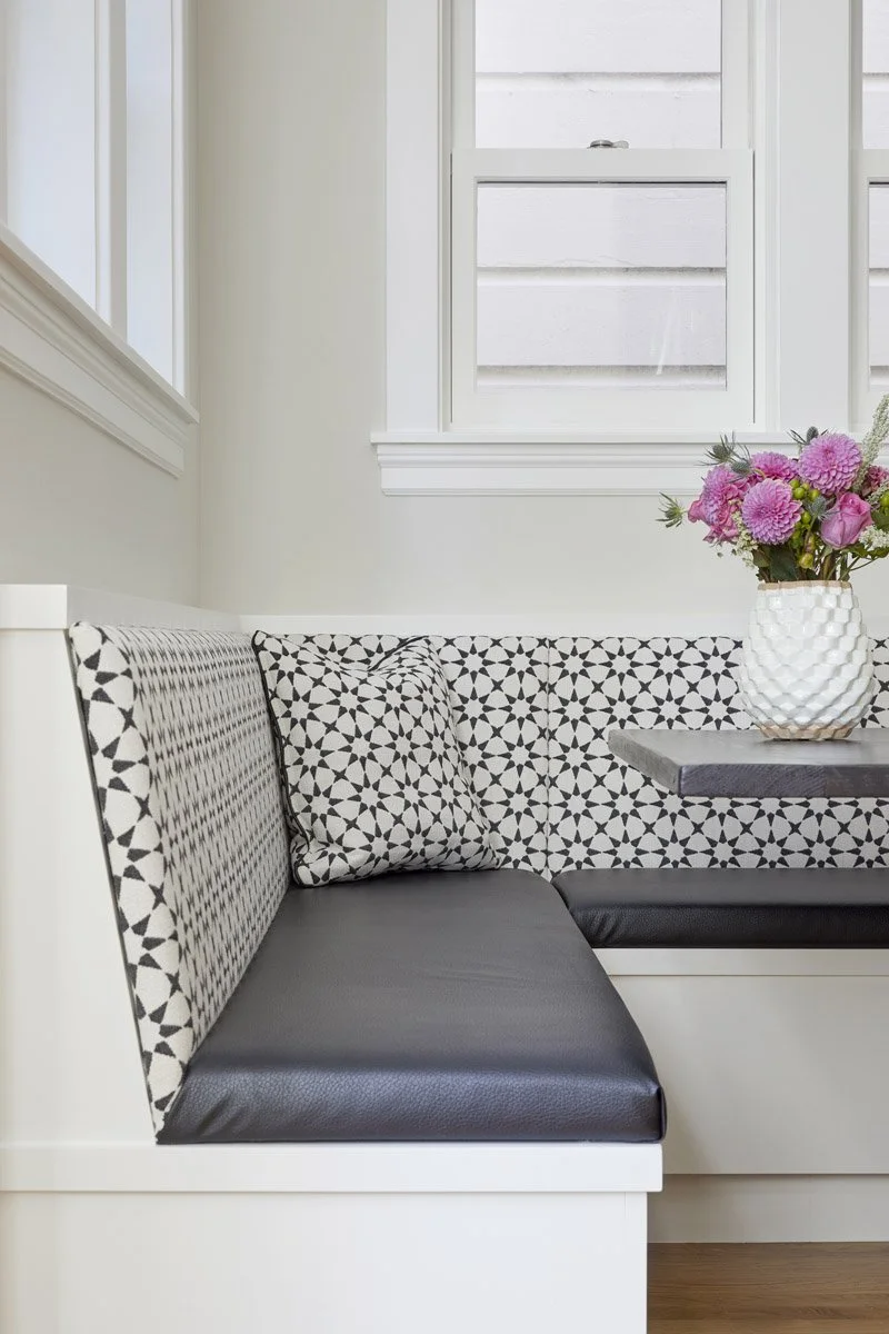 built-in banquette upholstered in black and white patterned fabric