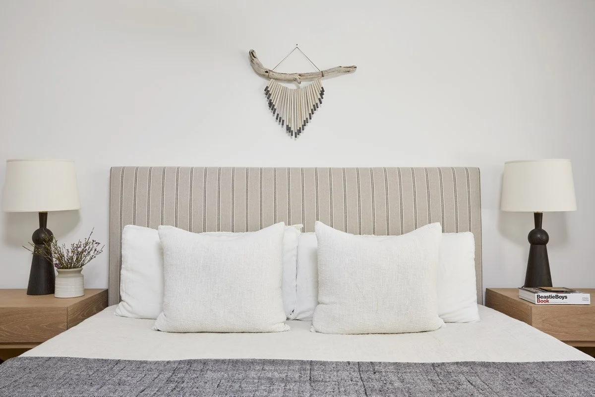 bedroom with channelled headboard, white bedding and matching bedside lamps