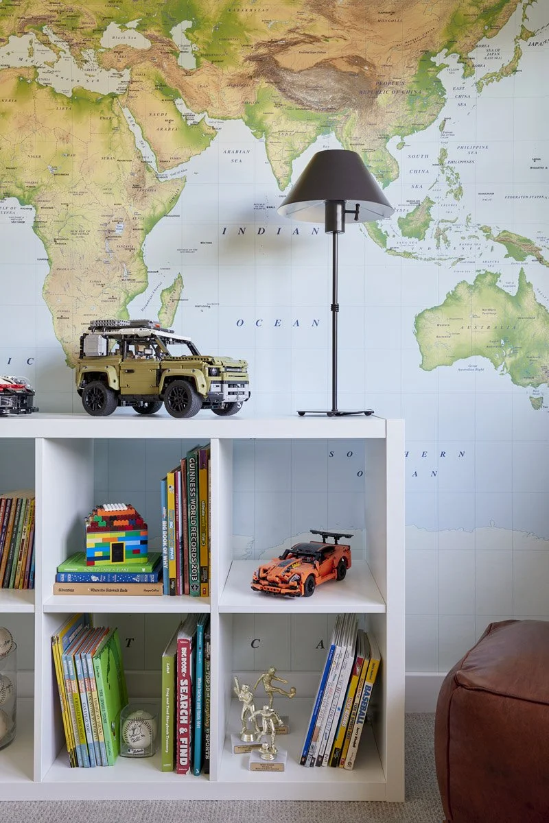 kids bedroom with world map wallpaper and cube bookshelf of toys