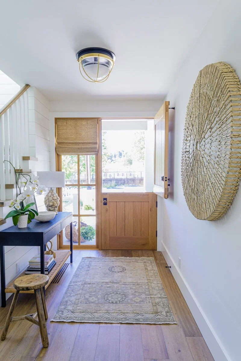 entry hall with dutch door, round woven wall hanging and console table