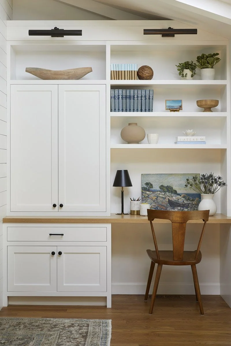 built-in desk nook with white cabinetry, open shelving and wooden chair