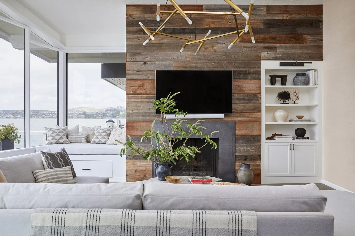 living room with reclaimed wood fireplace wall, sectional sofa and brass chandelier