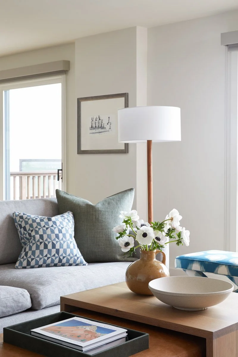 sofa with patterned pillows, floor lamp and wood coffee table