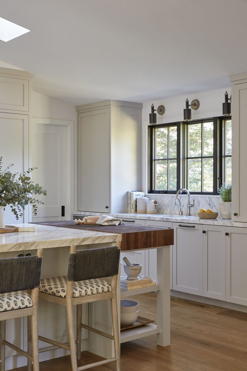 kitchen island with butcher block end and woven counter stools