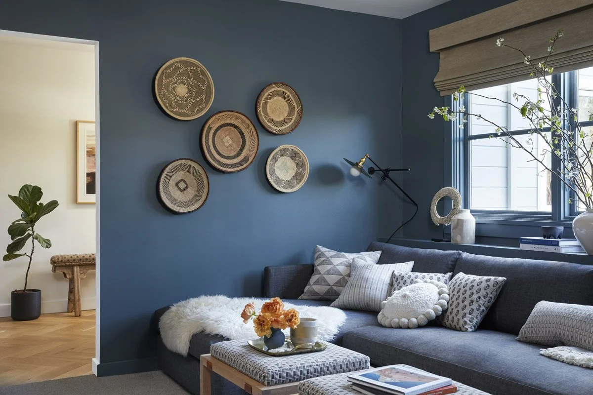 blue family room with sectional sofa and woven baskets hung on the wall
