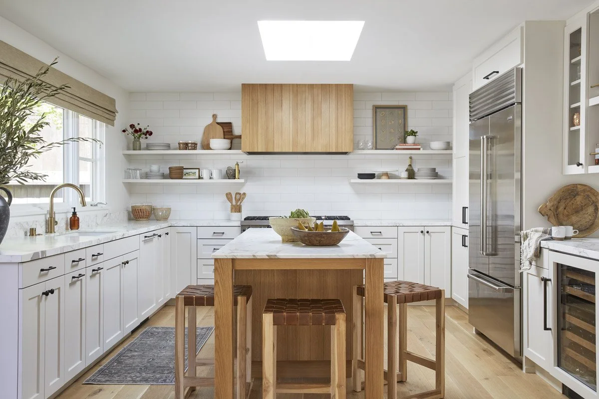 white kitchen with white oak island, wooden stools and open shelving