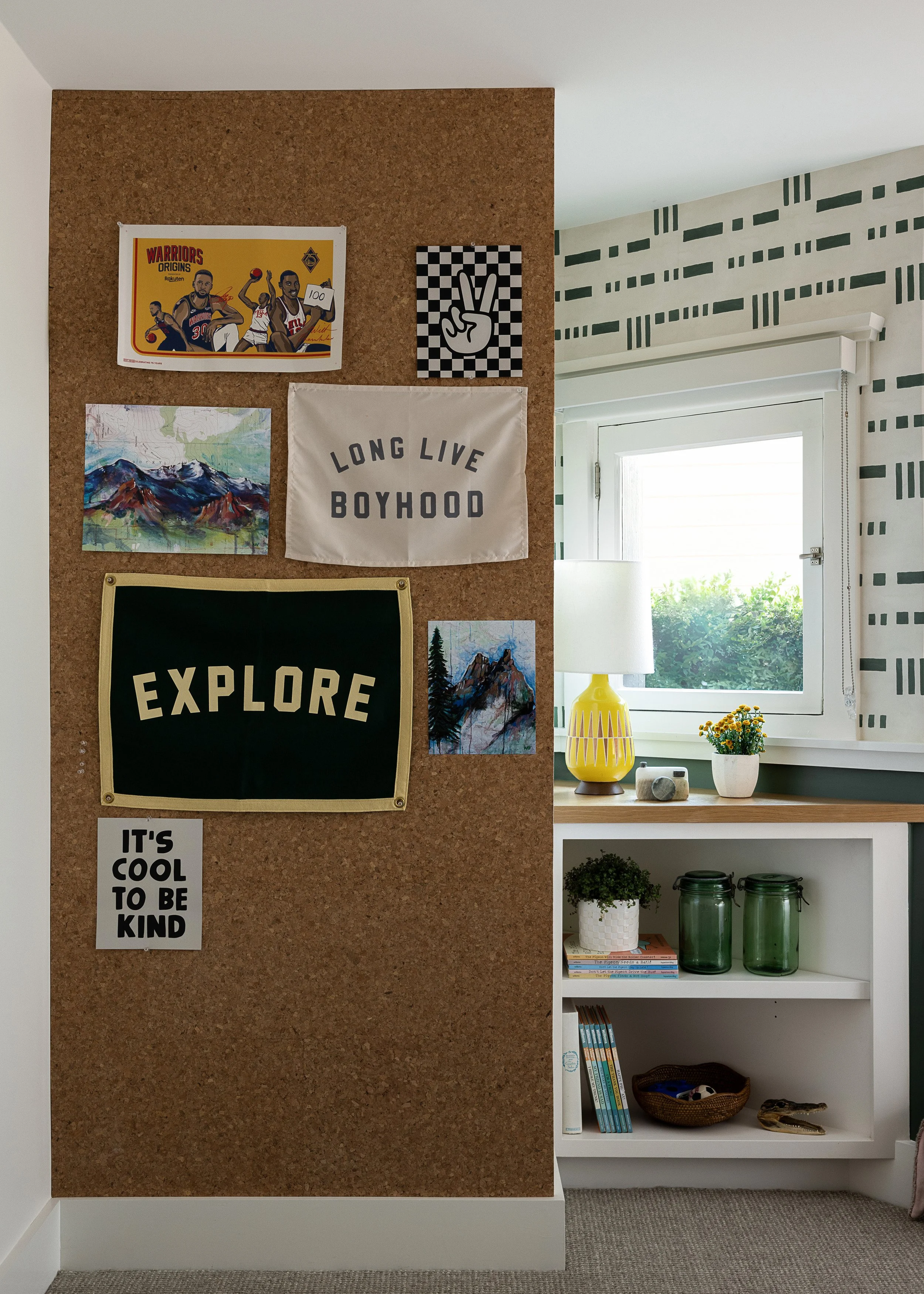 kids room with cork pinboard wall, framed pennant and white shelving