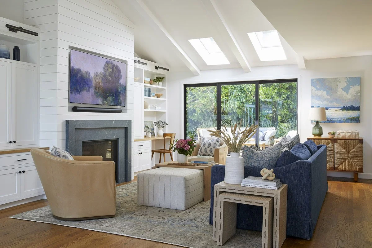 bright living room with skylights, navy sofa and swivel armchairs