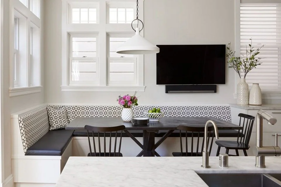 kitchen island looking into a breakfast nook with banquette seating