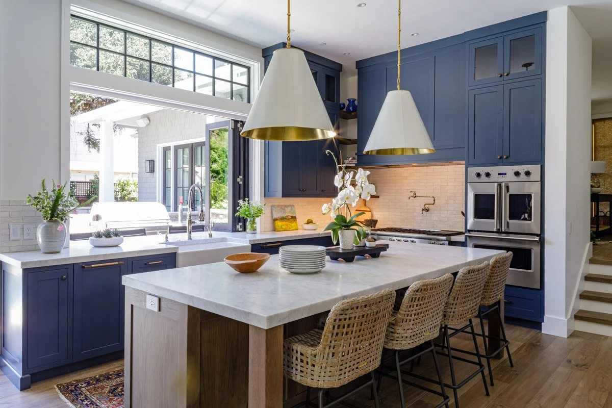 kitchen with navy cabinetry, white oak island and oversized white pendants
