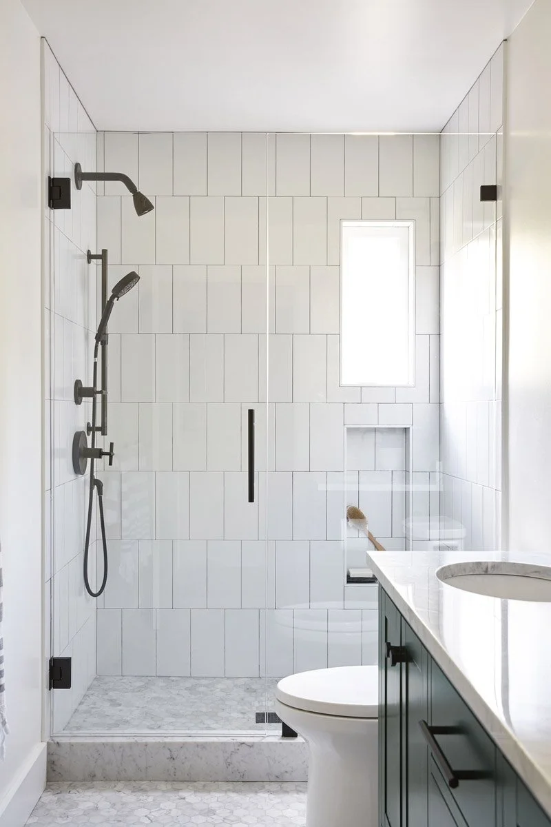 walk-in shower with white vertical tile and matte black fixtures