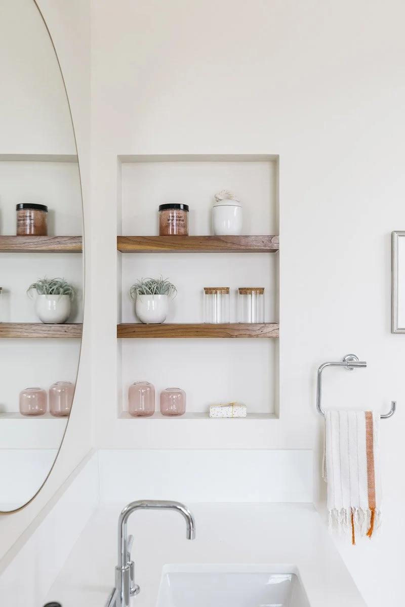 recessed bathroom shelves with walnut ledges and toiletries