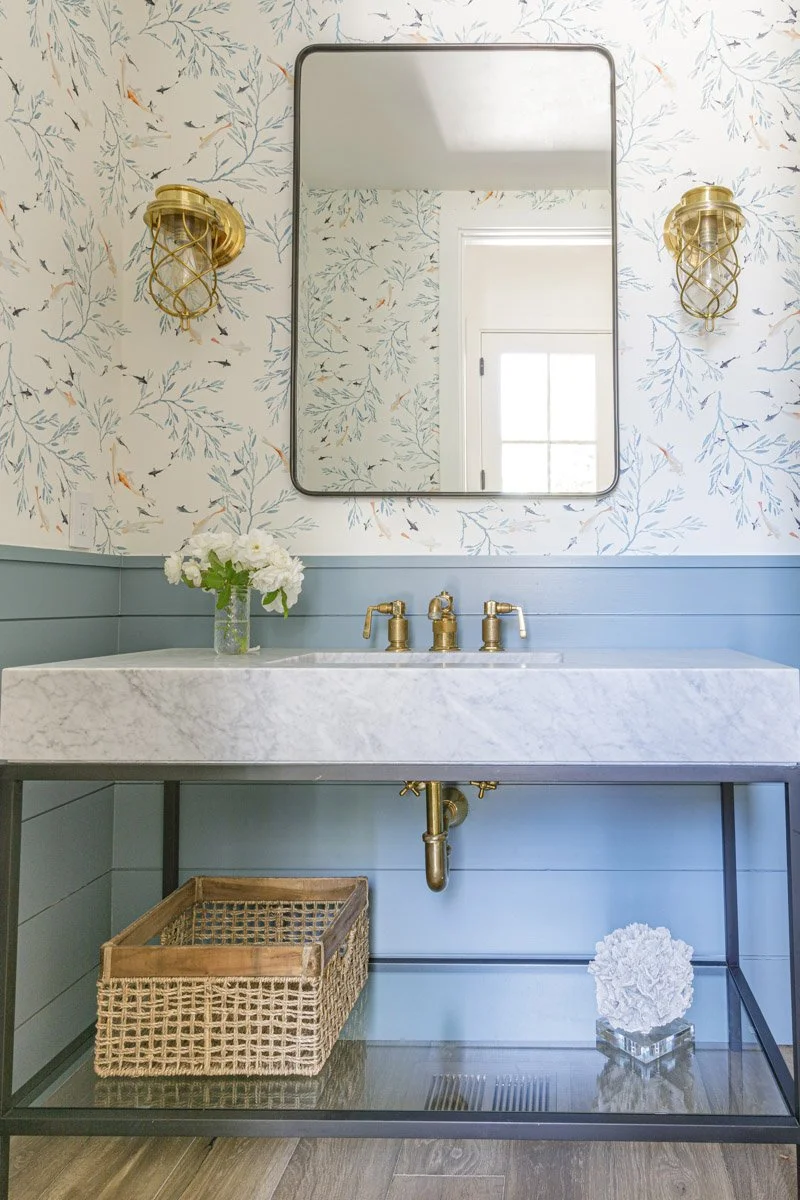 powder room with botanical wallpaper, brass mirror and marble console sink