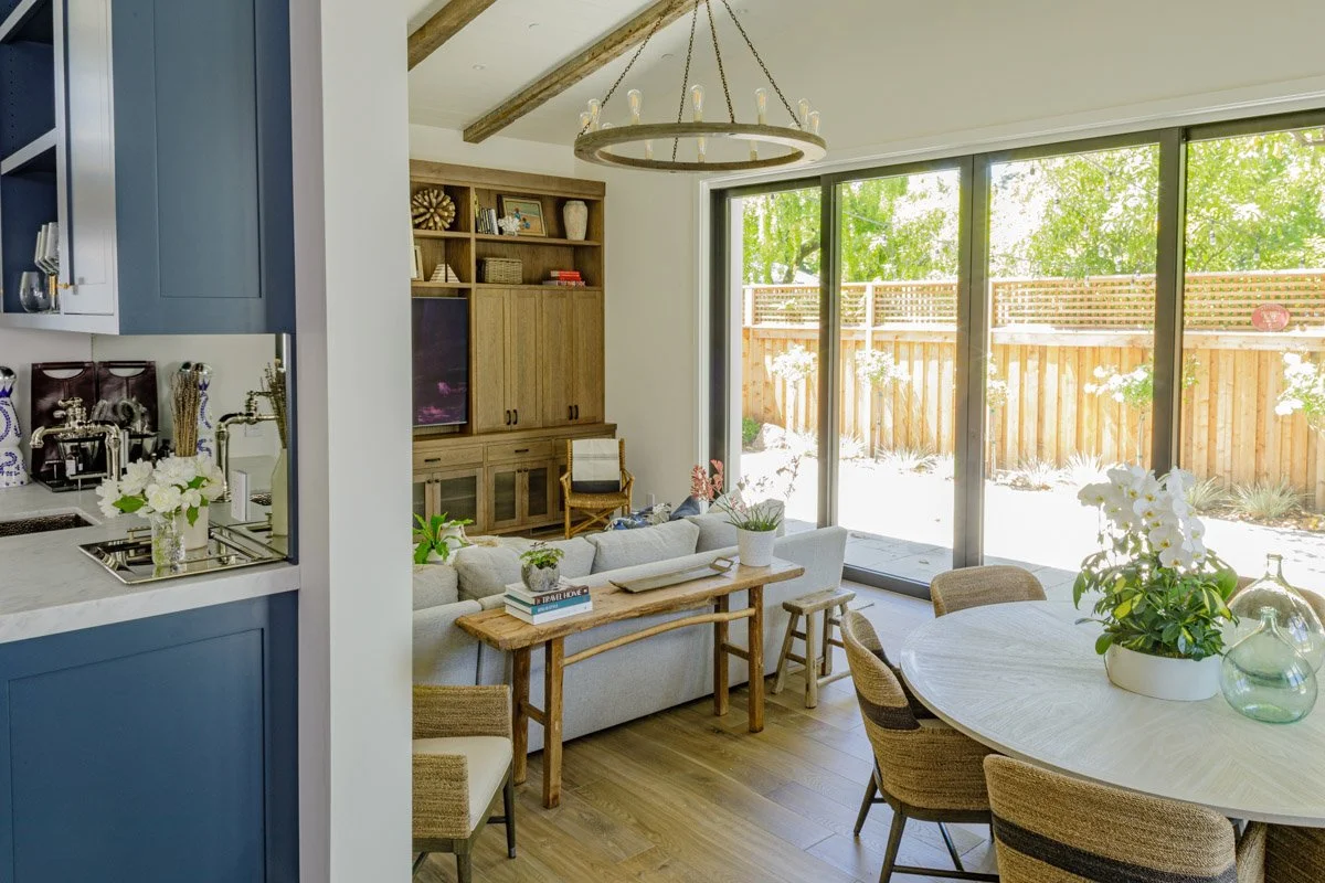 great room with navy cabinetry, round dining table and sliding glass doors