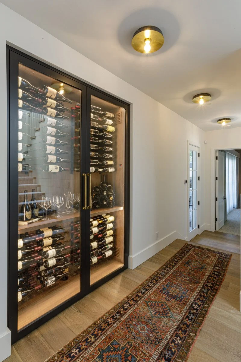 hallway with glass-front wine room and vintage runner