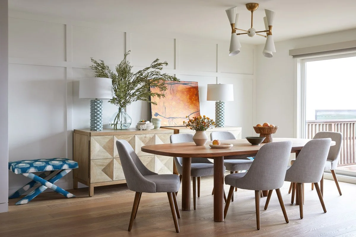 dining room with round wood table, grey upholstered chairs and brass chandelier