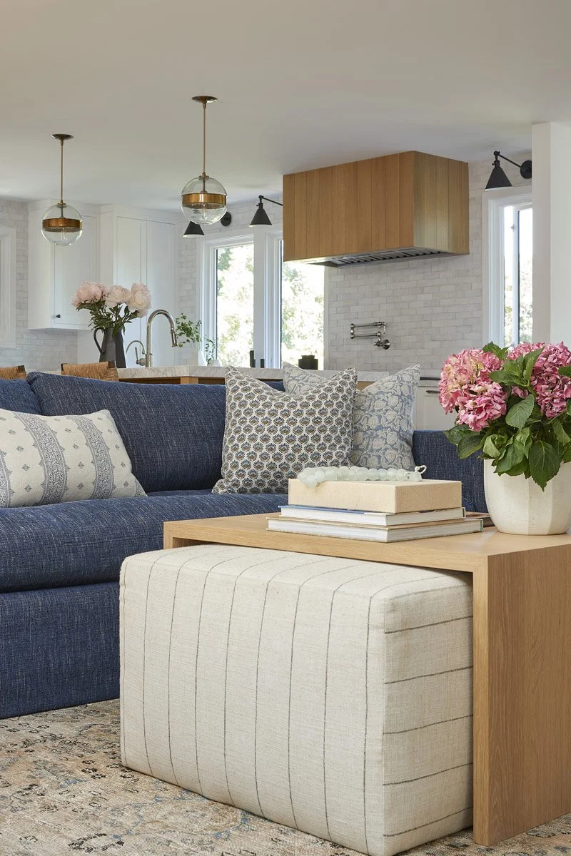 navy sofa and striped ottoman looking towards the kitchen