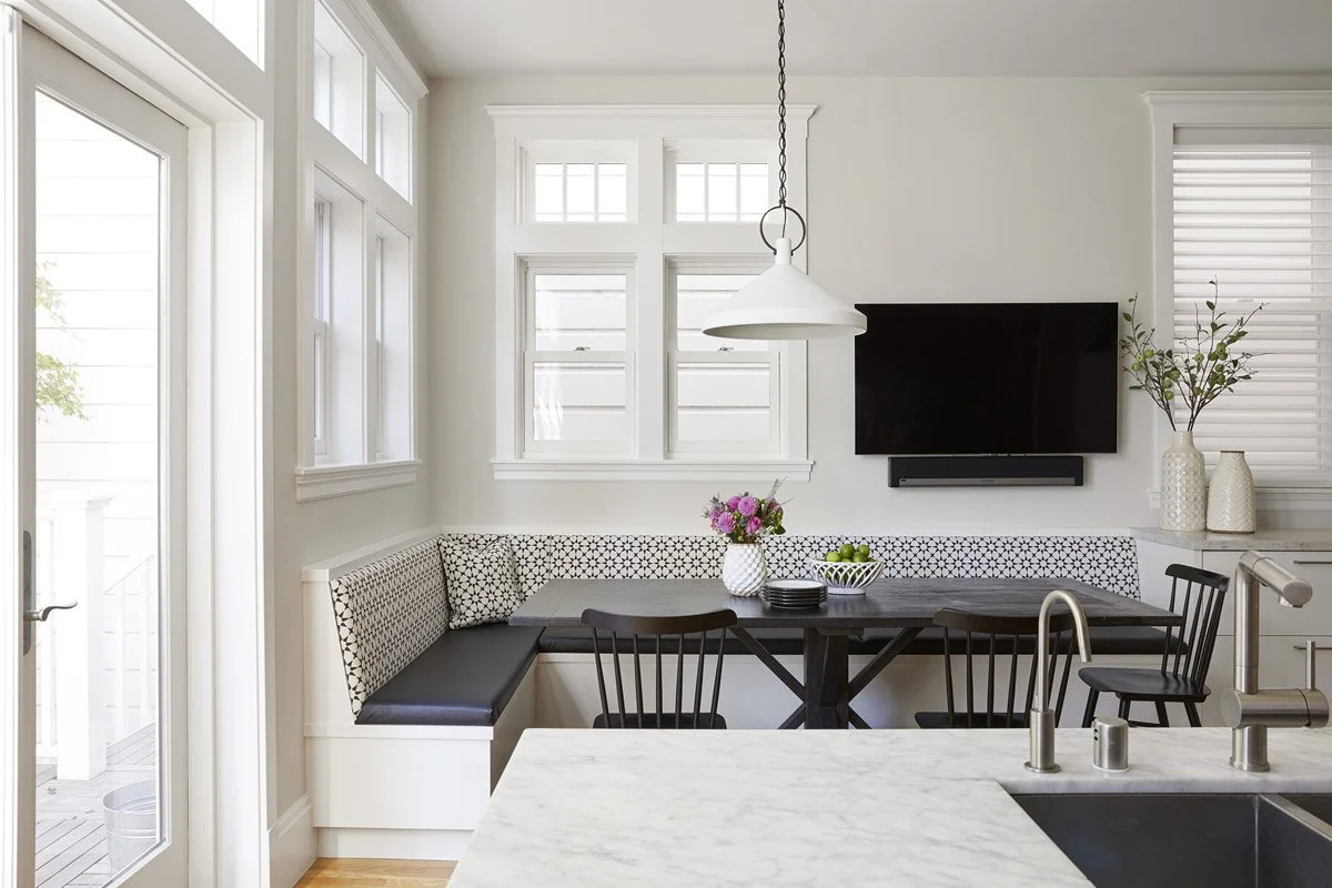 kitchen island looking into a breakfast nook with banquette seating
