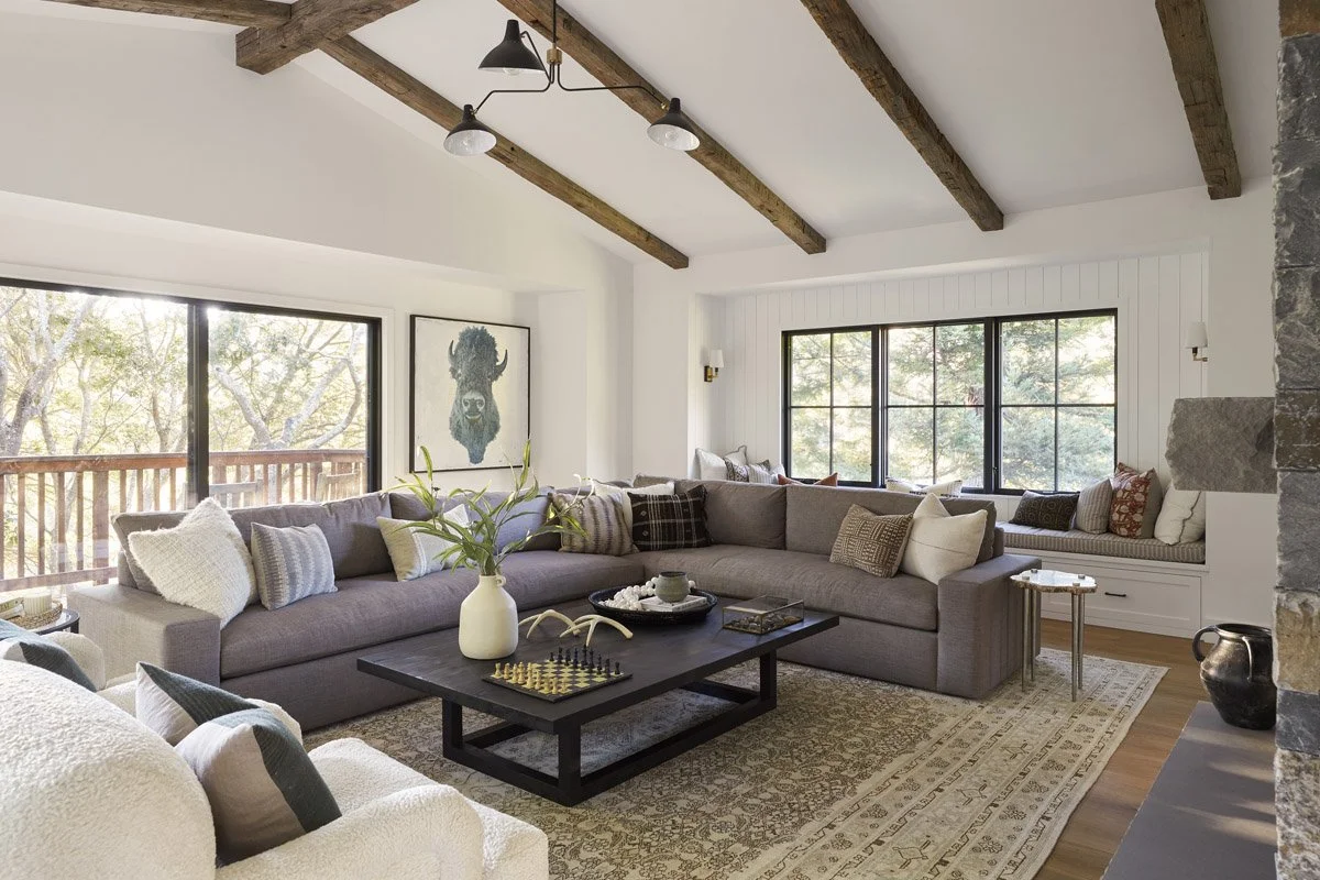 great room with sectional sofa, vintage rug and black-framed windows