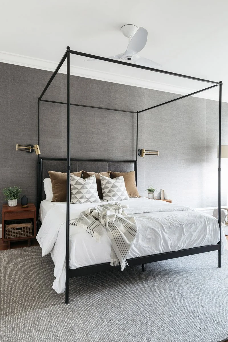 primary bedroom with black four-poster bed and grey grasscloth walls