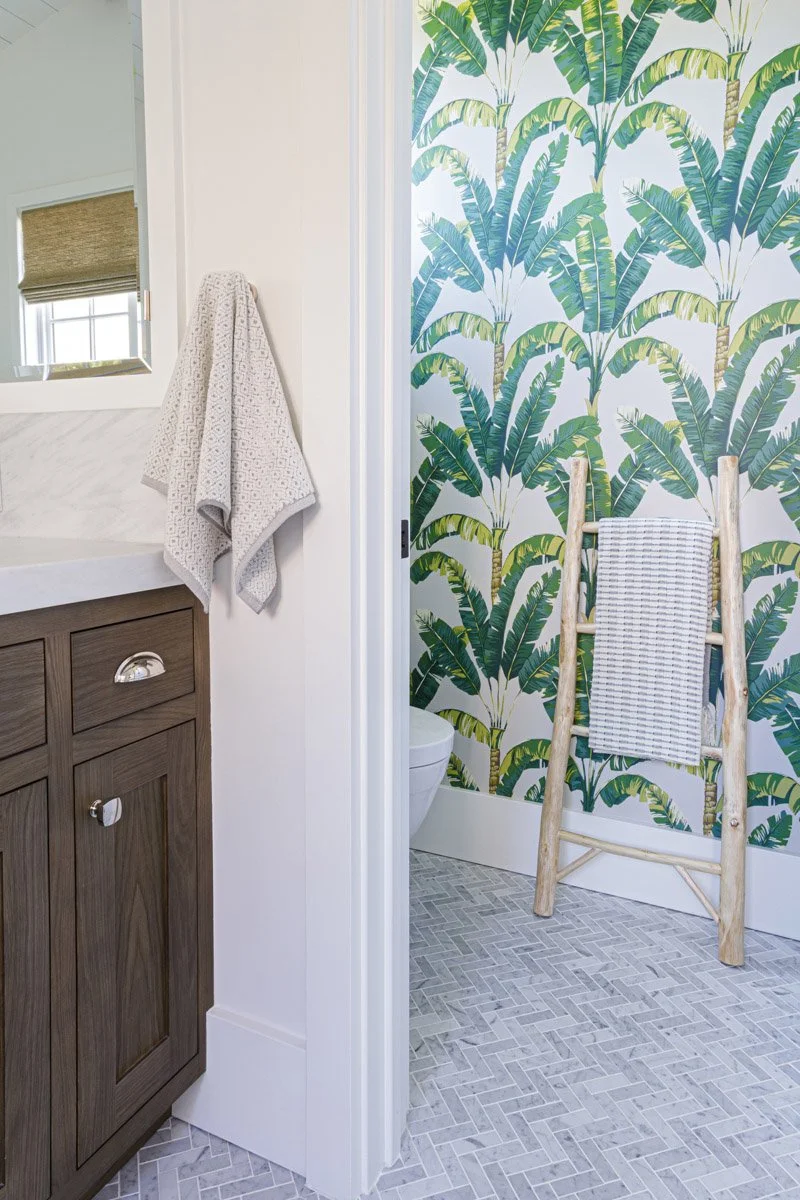 bathroom with palm leaf wallpaper and dark wood vanity