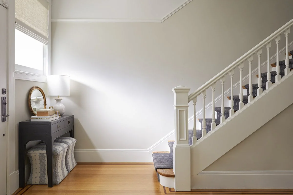 entry hall with white staircase, console table and round mirror