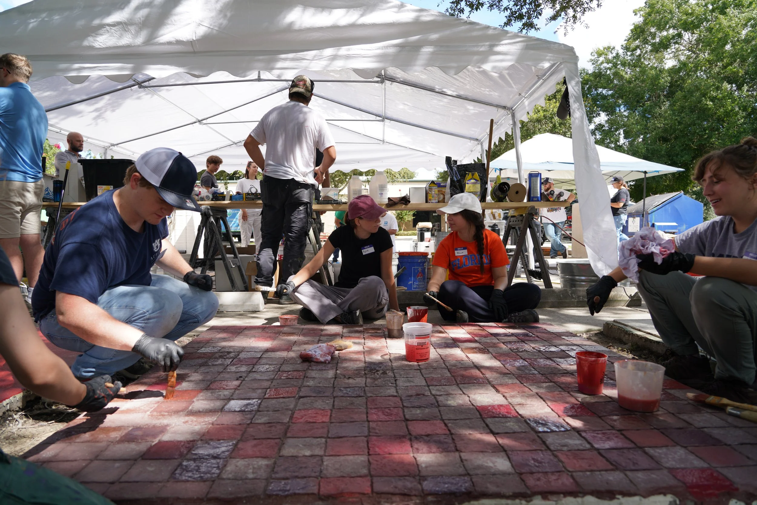 Students use tinted sealer to color a stamped and textured overlay flooring system.JPG