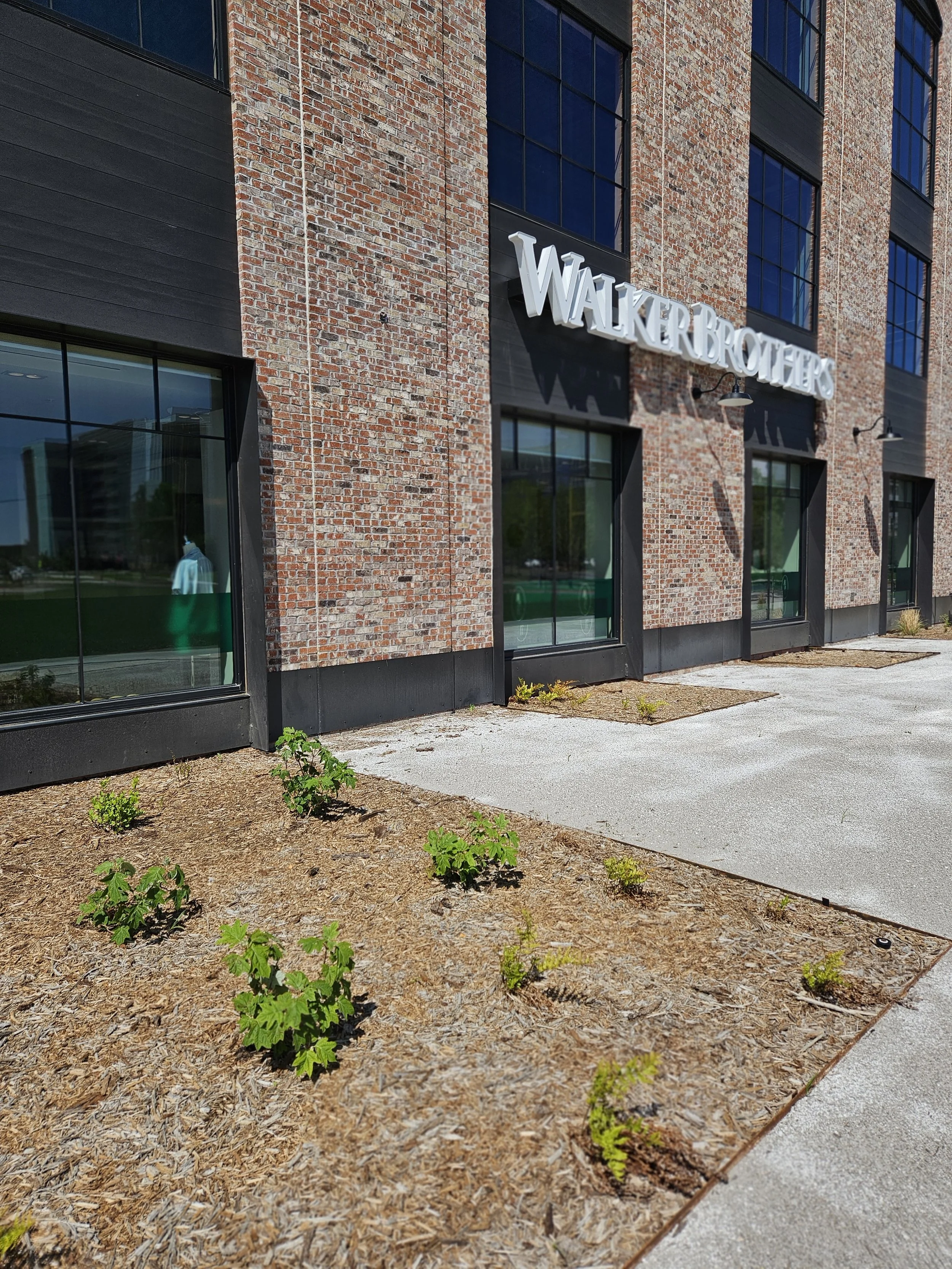 Exterior of a brick building with large windows and the sign 'Walker Brothers' on the side.