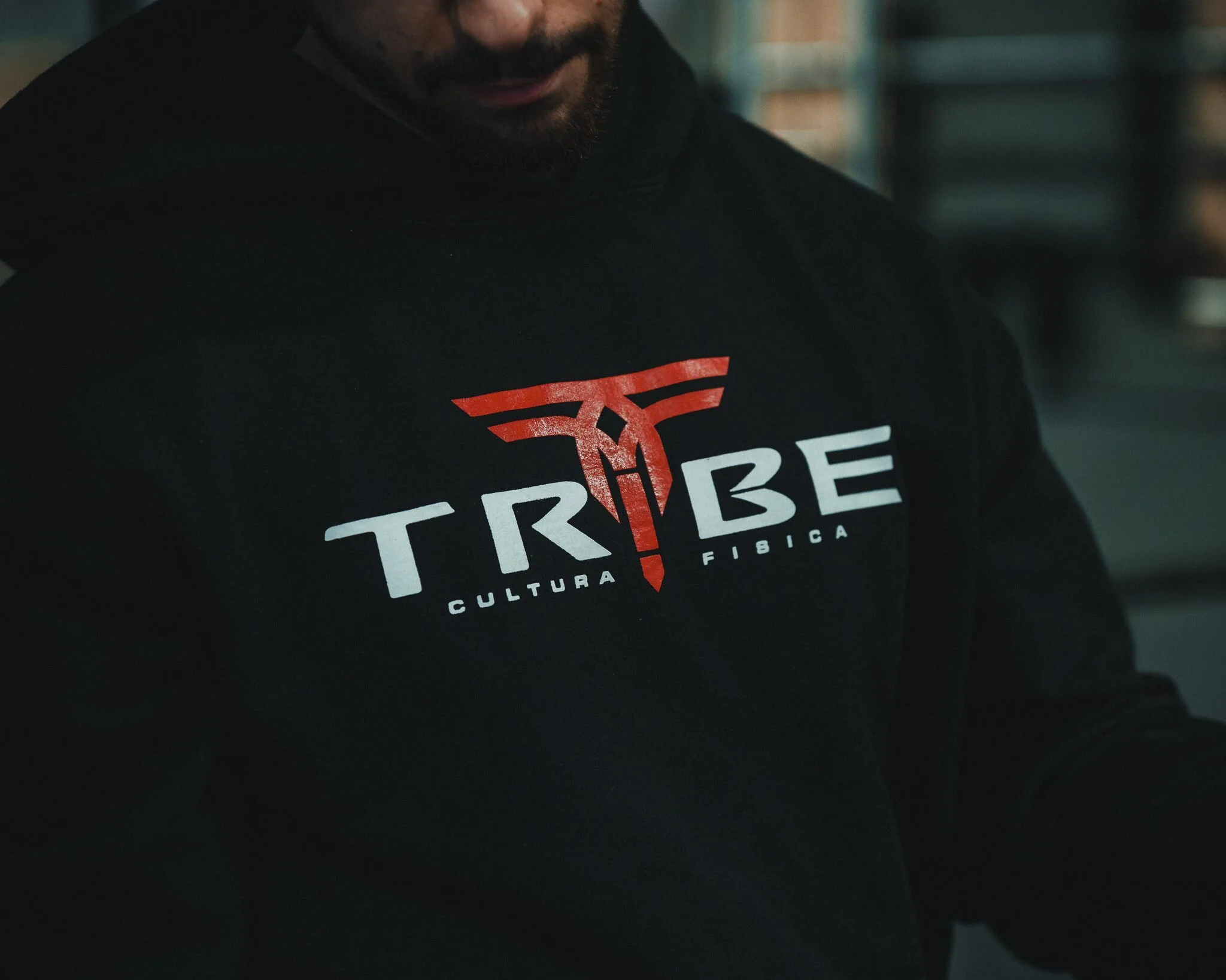 Uomo con barba che indossa una maglietta con il logo della squadra di calcio Trento.