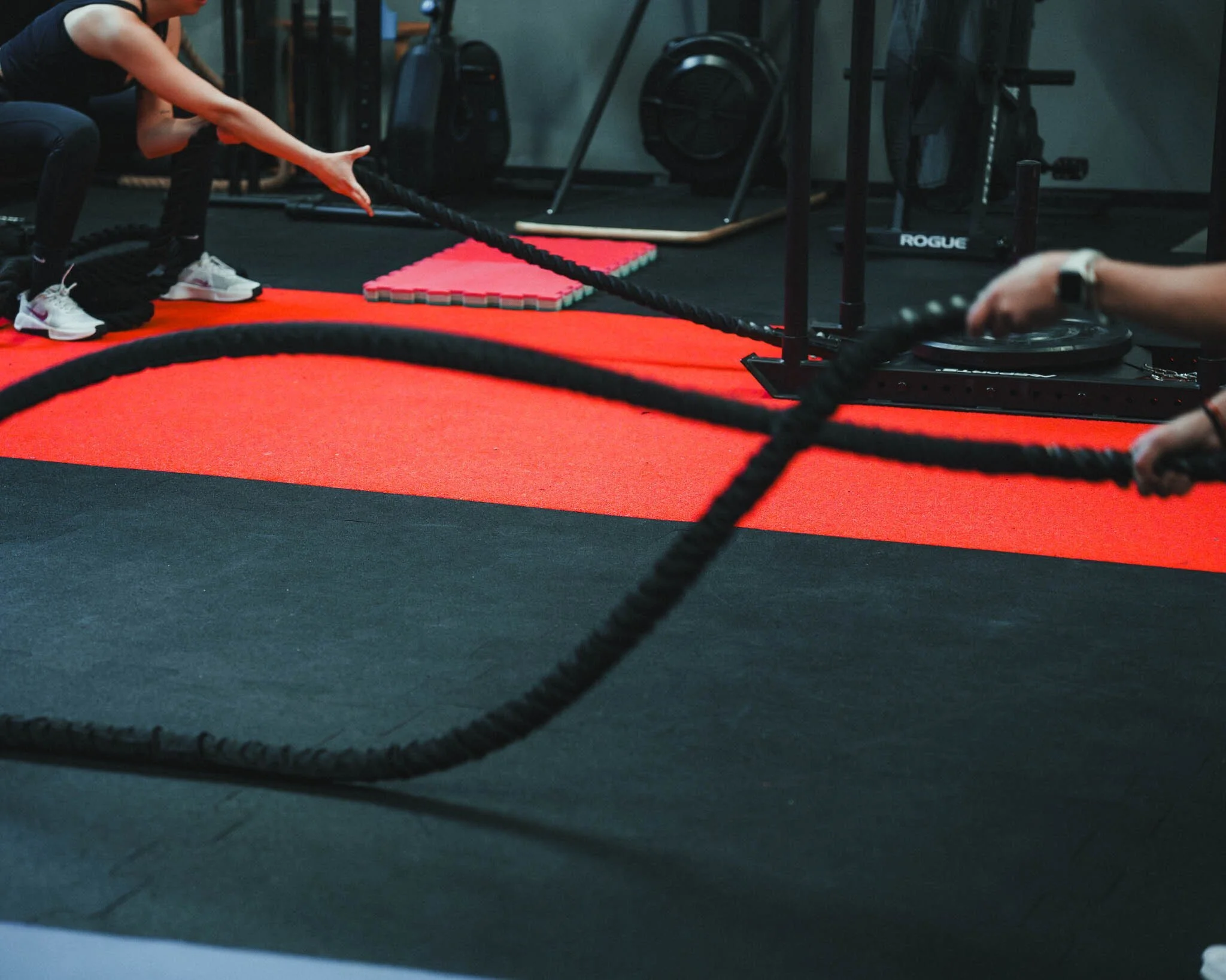 Una donna che fa esercizi di allenamento con la corda nel palestra.