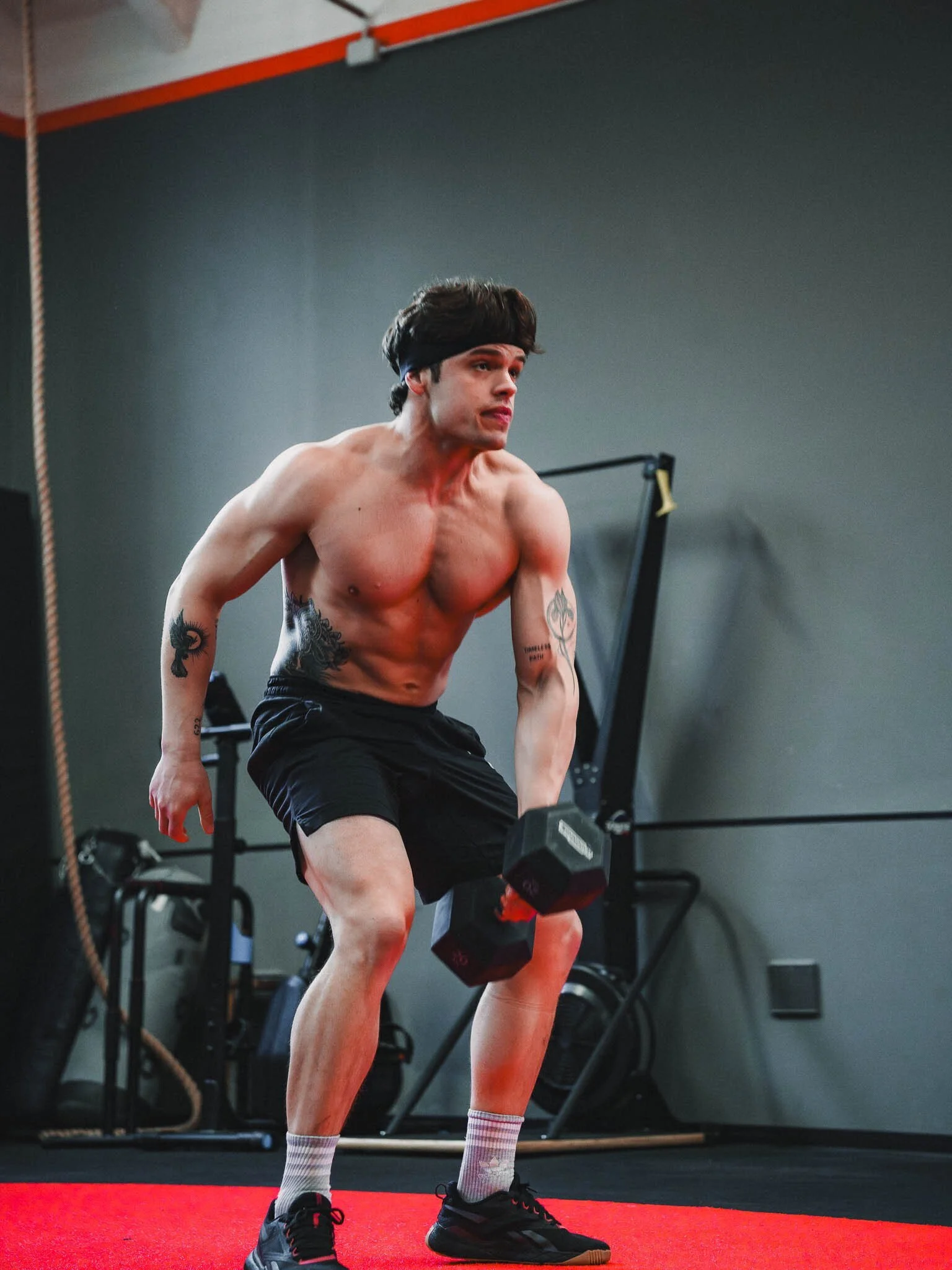 Uomo che fa esercizi di sollevamento pesi con manubri in palestra