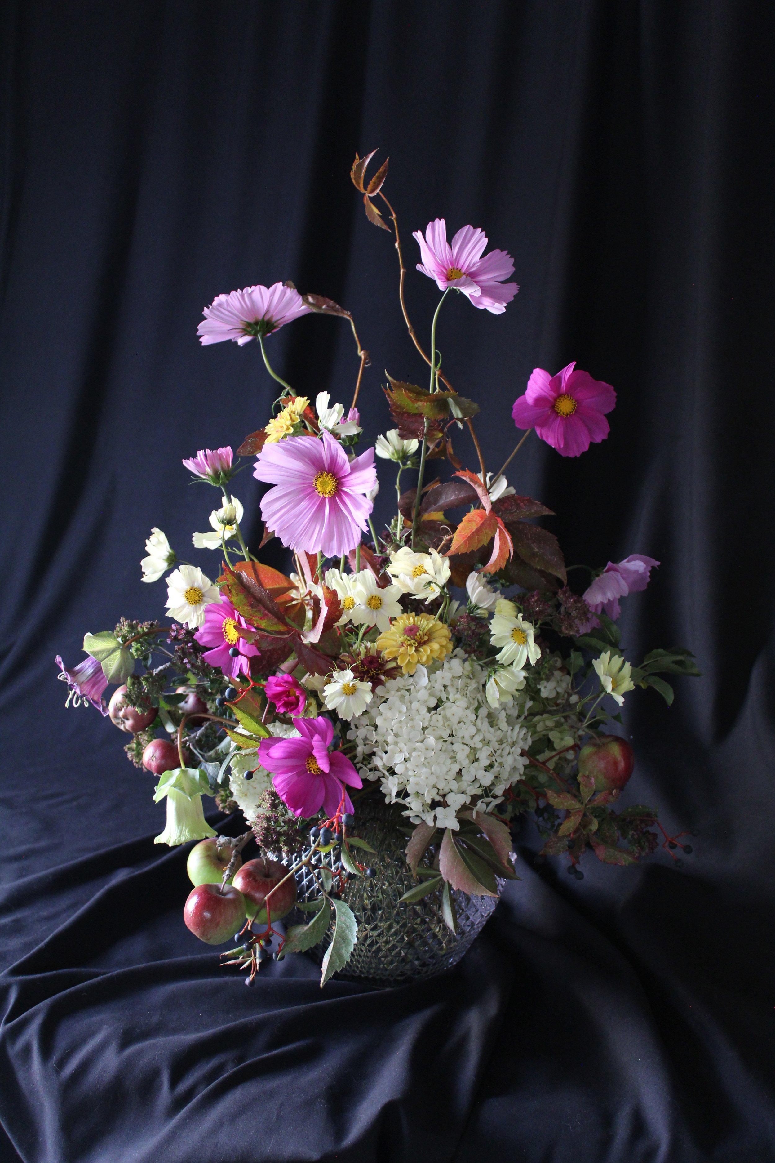 A fall arrangement featuring cosmos, crabapple, hydrangeas, and zinnias.