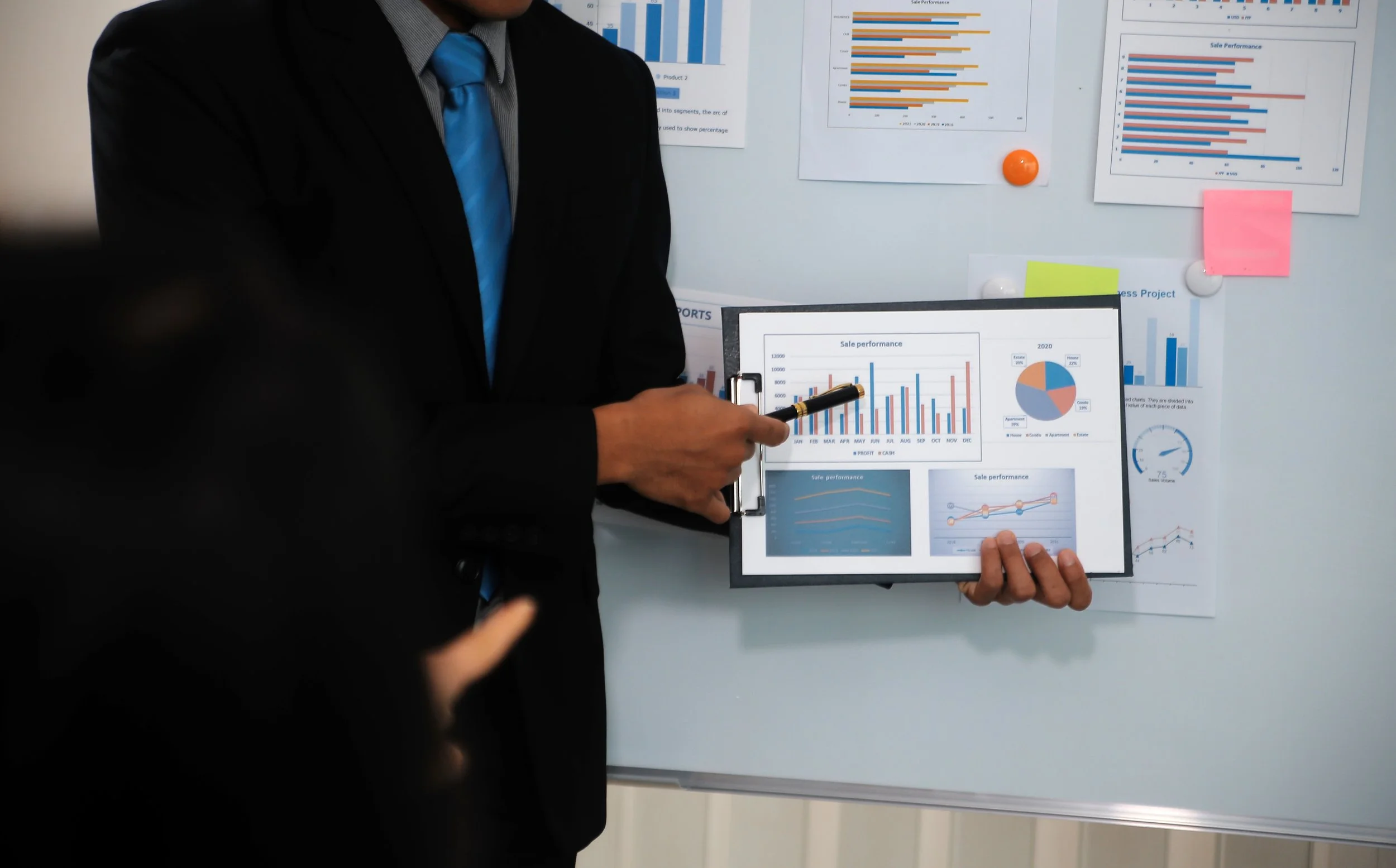 a man holding a board presenting statistics and graphs to work on business development and to drive sales. 