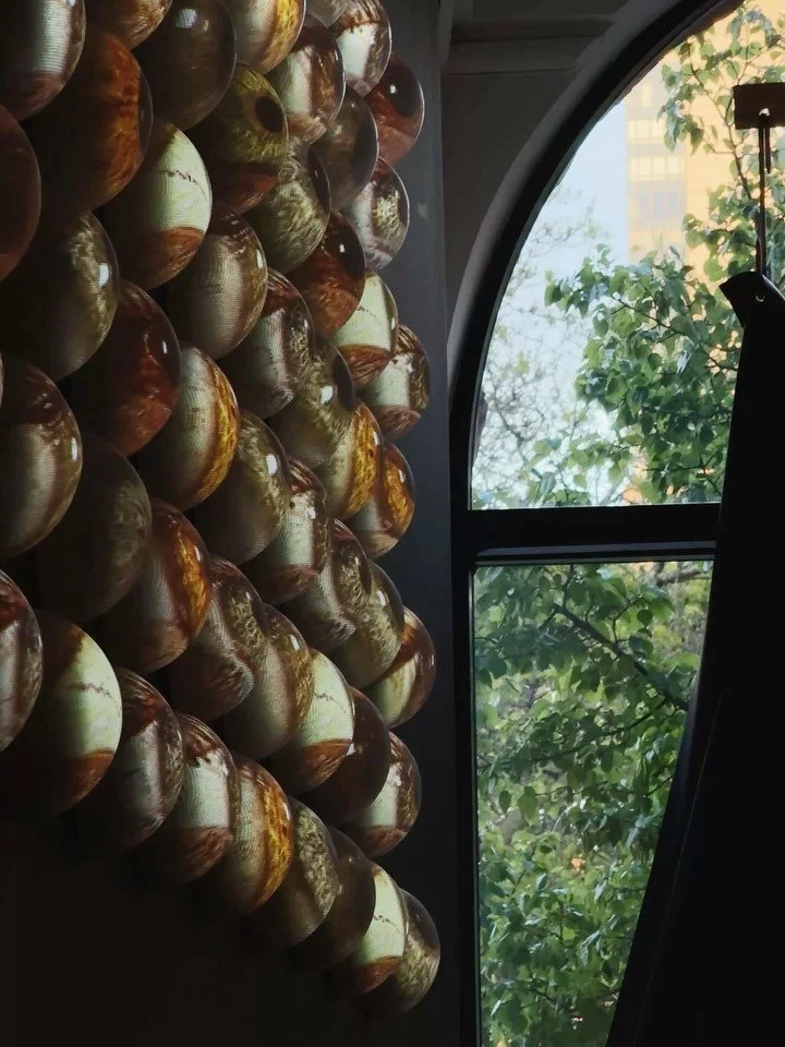 Untitled Studio&rsquo;s latest installation transforms a sculptural grid of domed forms into a surface of quiet intensity. The eyes, filmed by the studio, are projection-mapped onto each form to create an eerily lifelike presence. The piece invites a