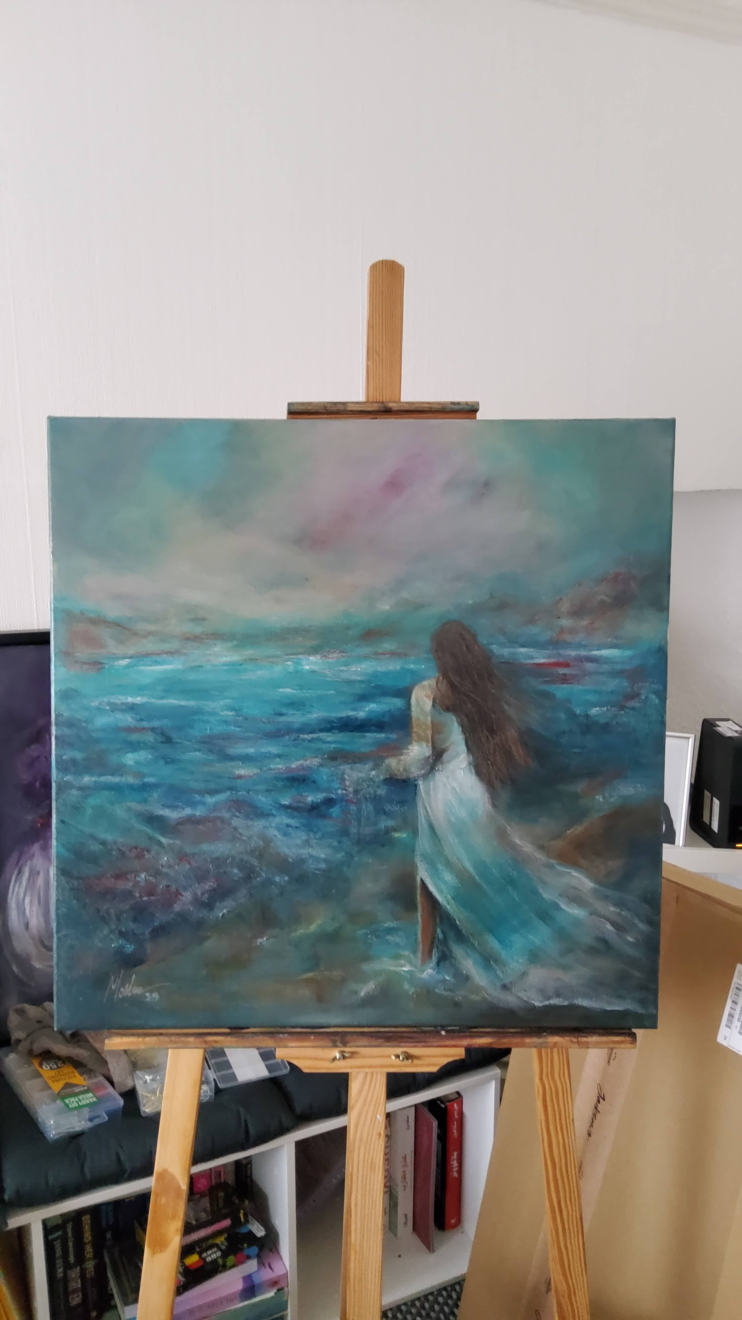 a painting of a woman on the beach on the easel to show the size of the painting