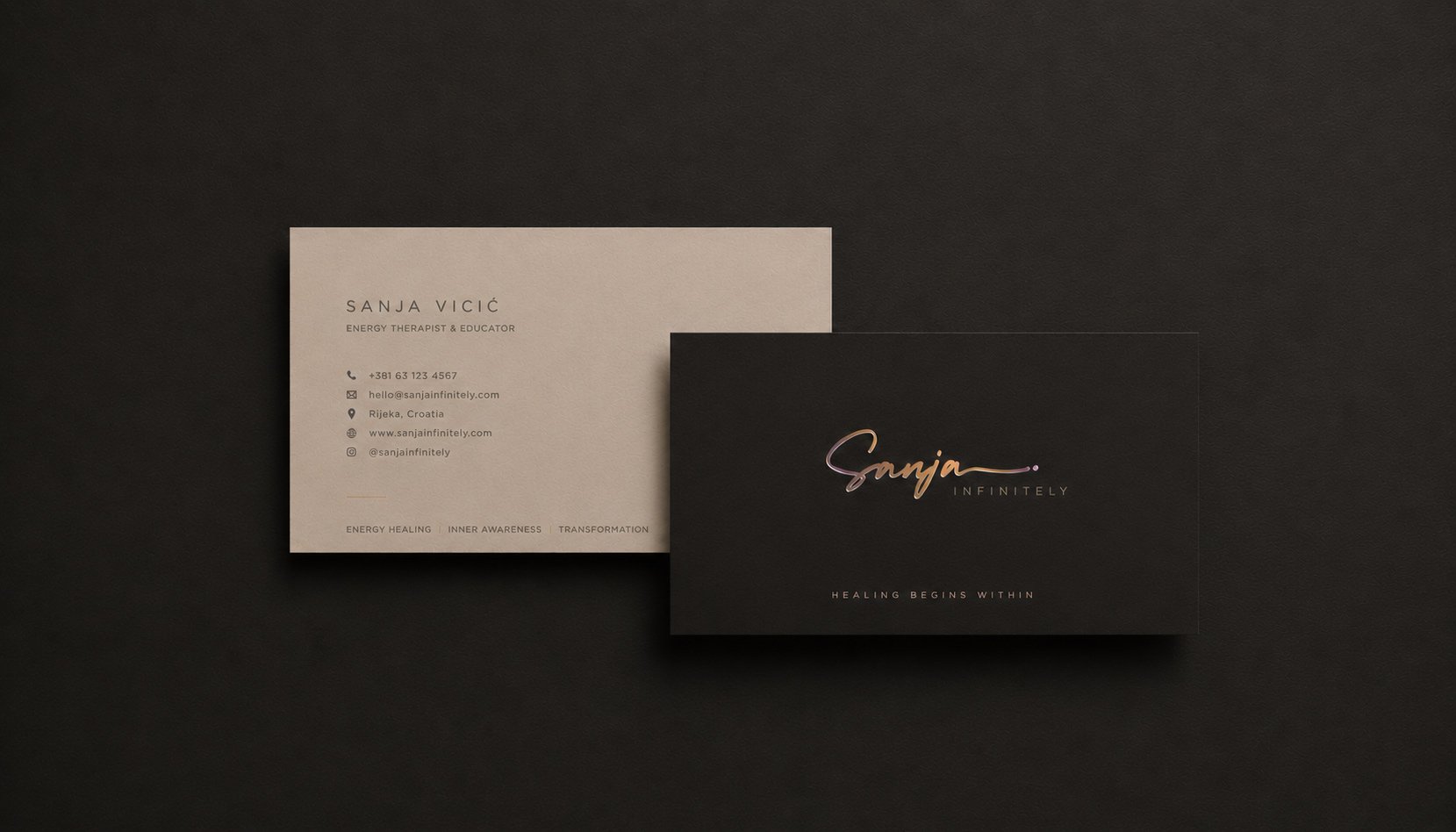 Luxury business card mockup for Sanja Infinitely energy healing brand with embossed gradient foil logo on textured dark paper background