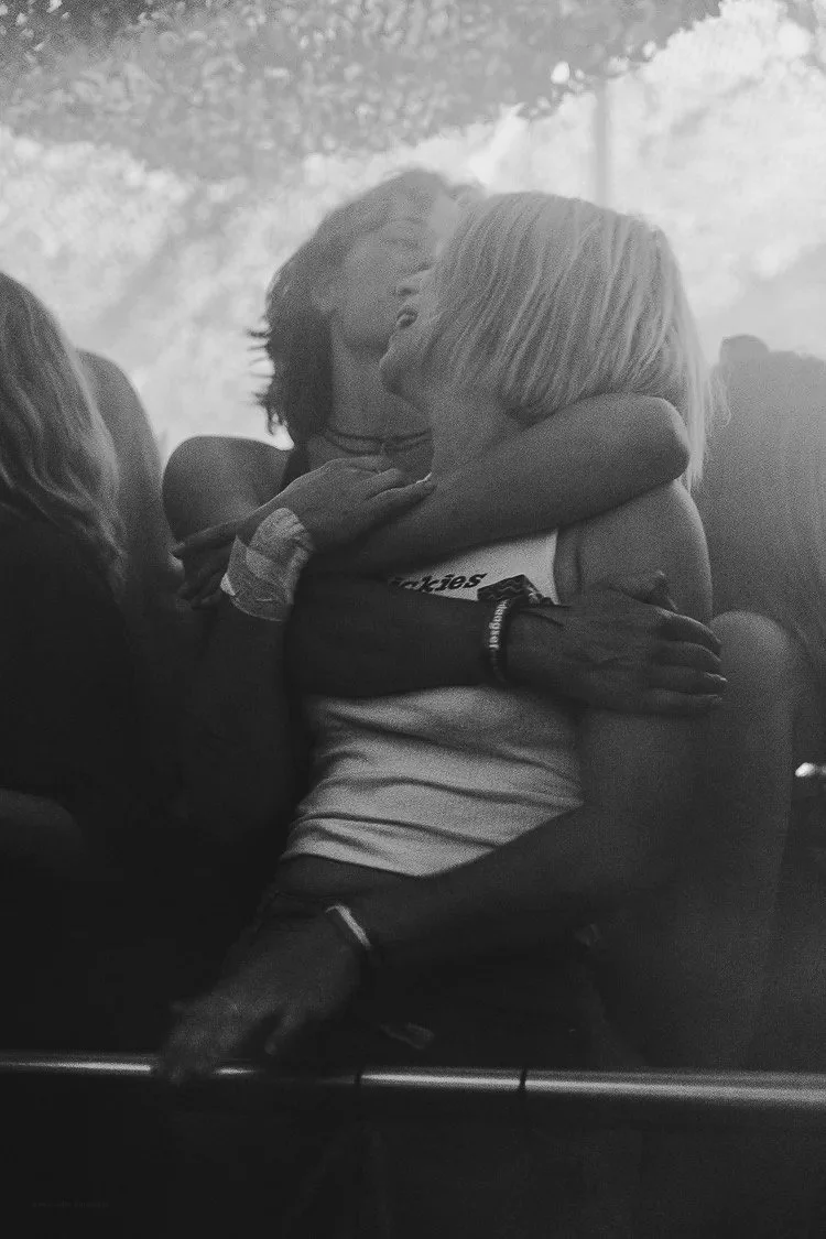 Two women embracing each other and smiling, with one woman hugging the other tightly.