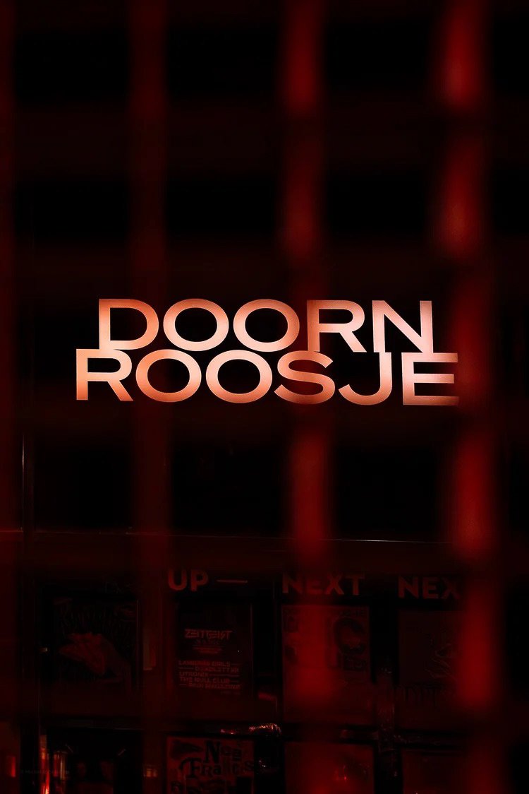 Neon sign displaying the text "DOURN ROOSJE" in red lighting.