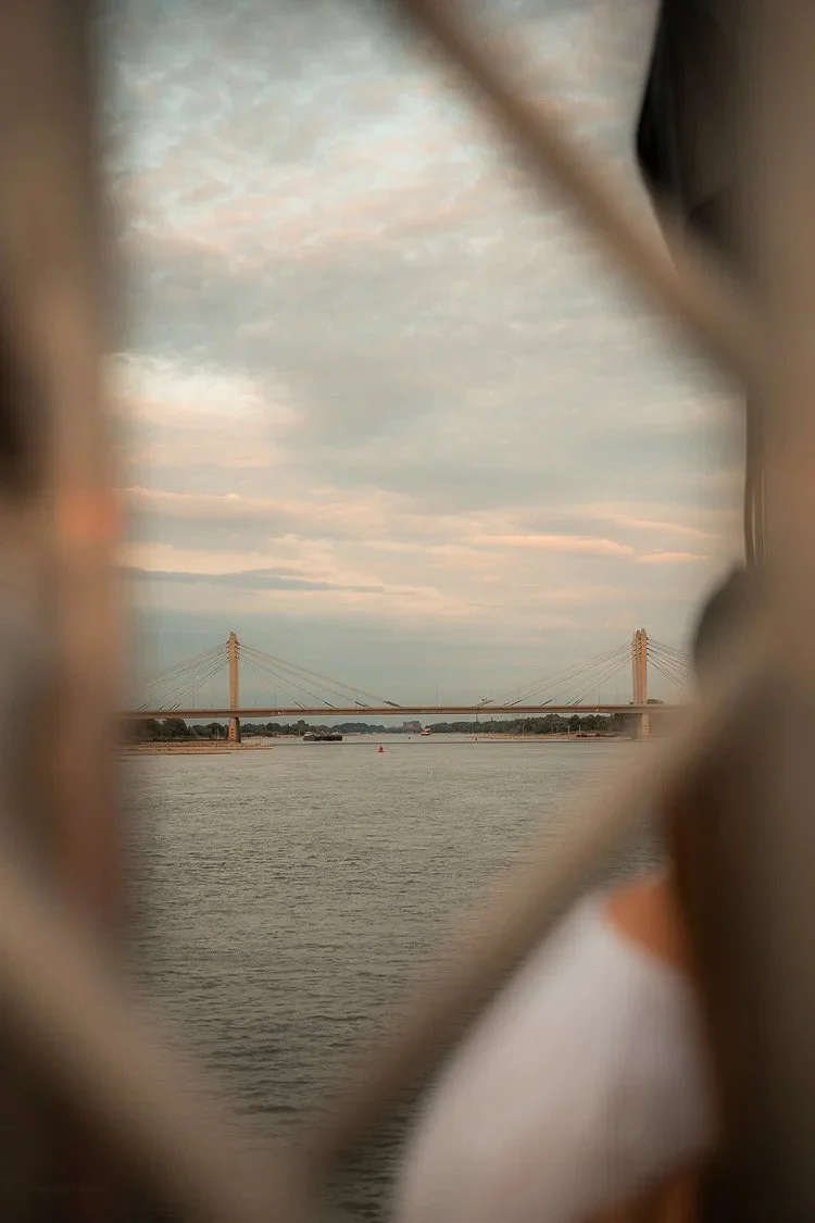 View of a bridge over a body of water, seen through a window or opening with blurred edges.