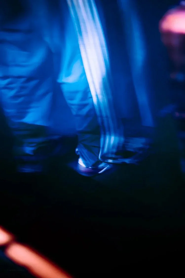 Abstract blue and purple light patterns with dark background.