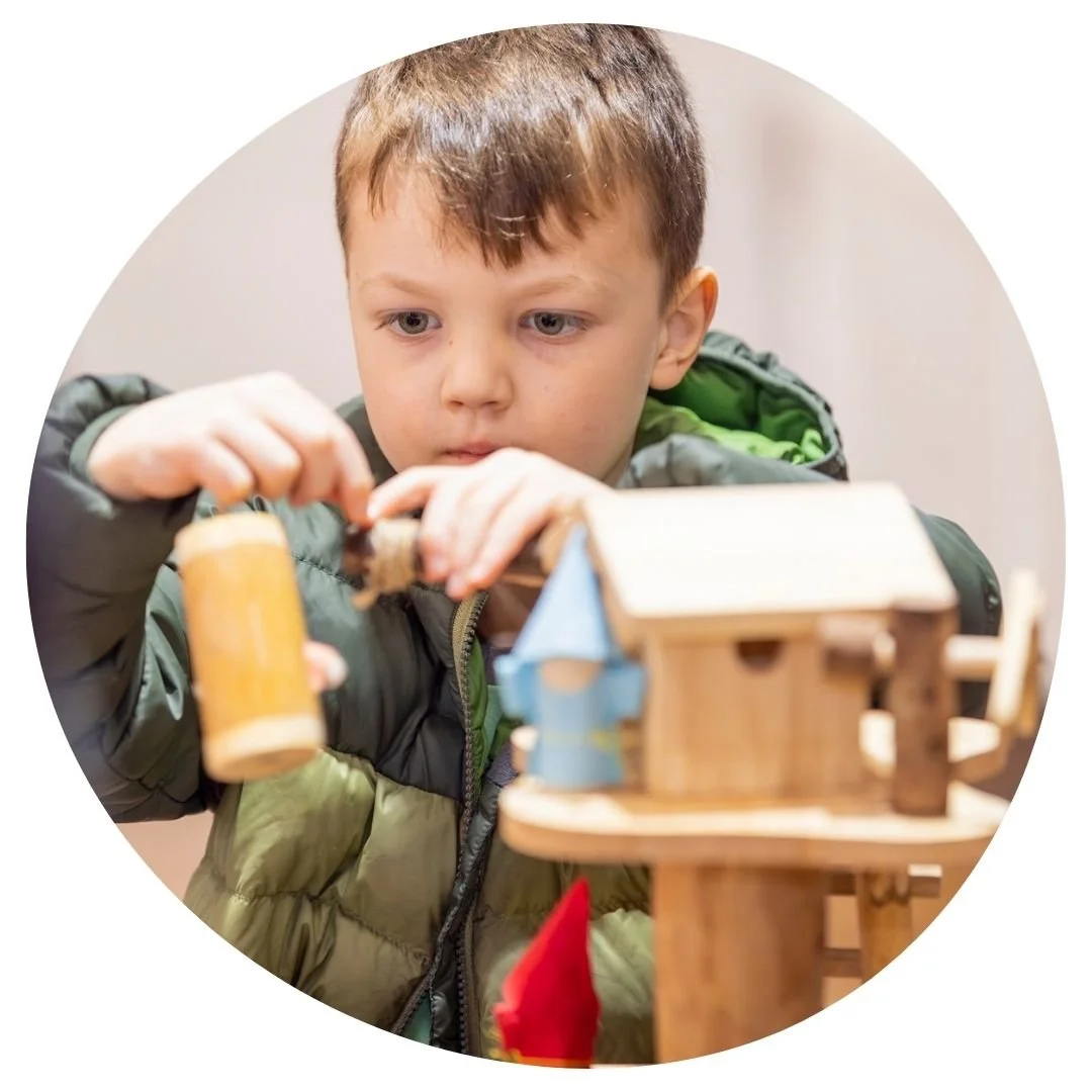 Child playing with wooden tree house toy