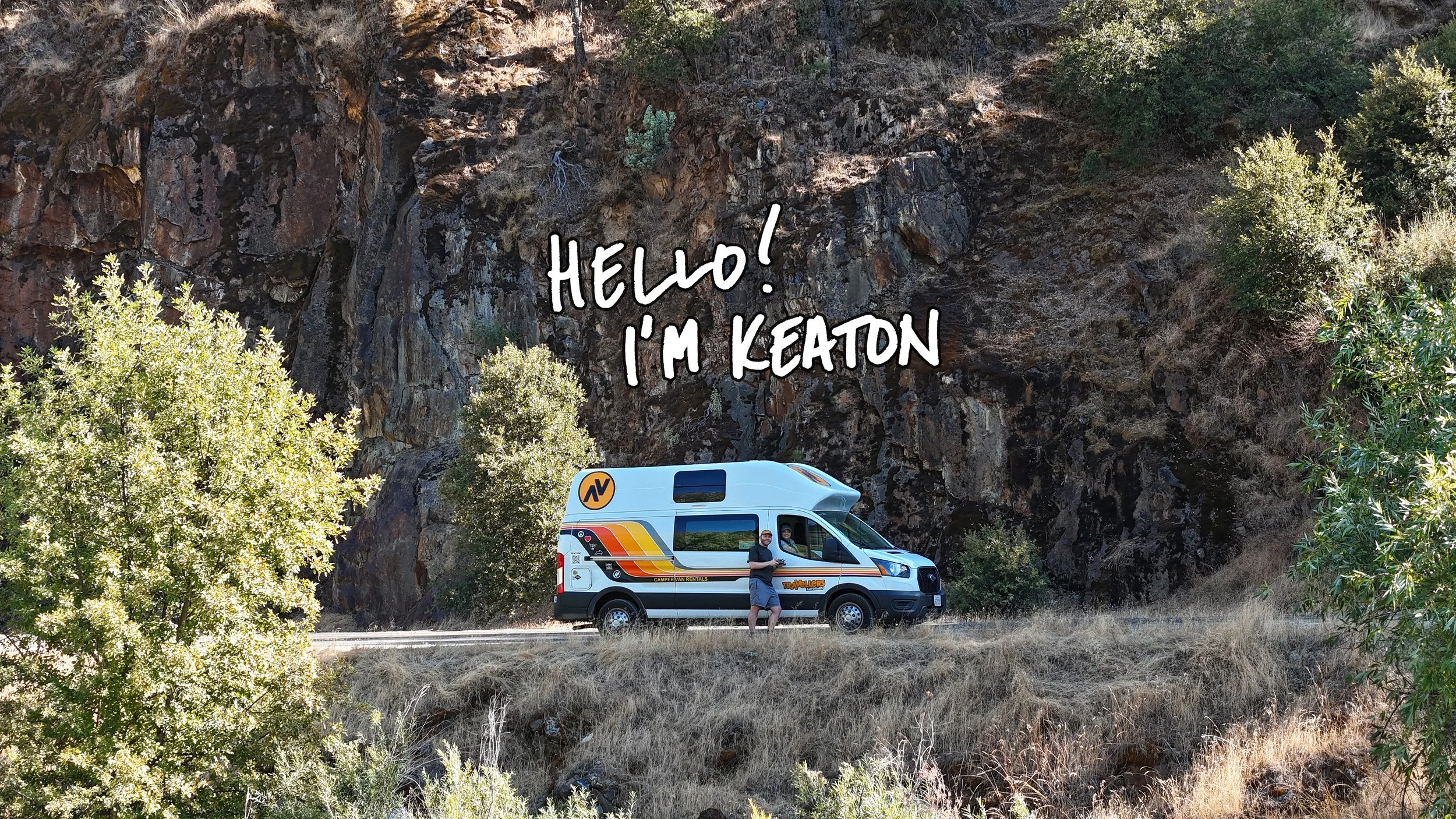 A person standing outside a camper van on a rural road, with rocky cliffs and trees in the background. Text on the image says, 'HELLO! I’M KEATON.'