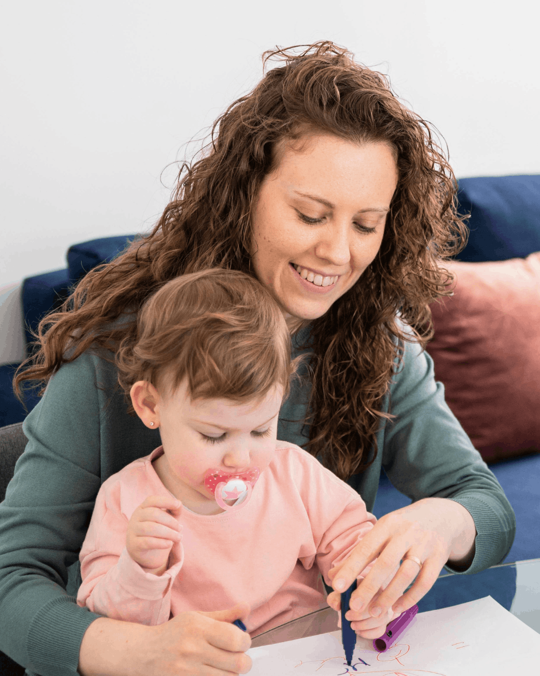 Nanny with little girl in her lap looking at a book