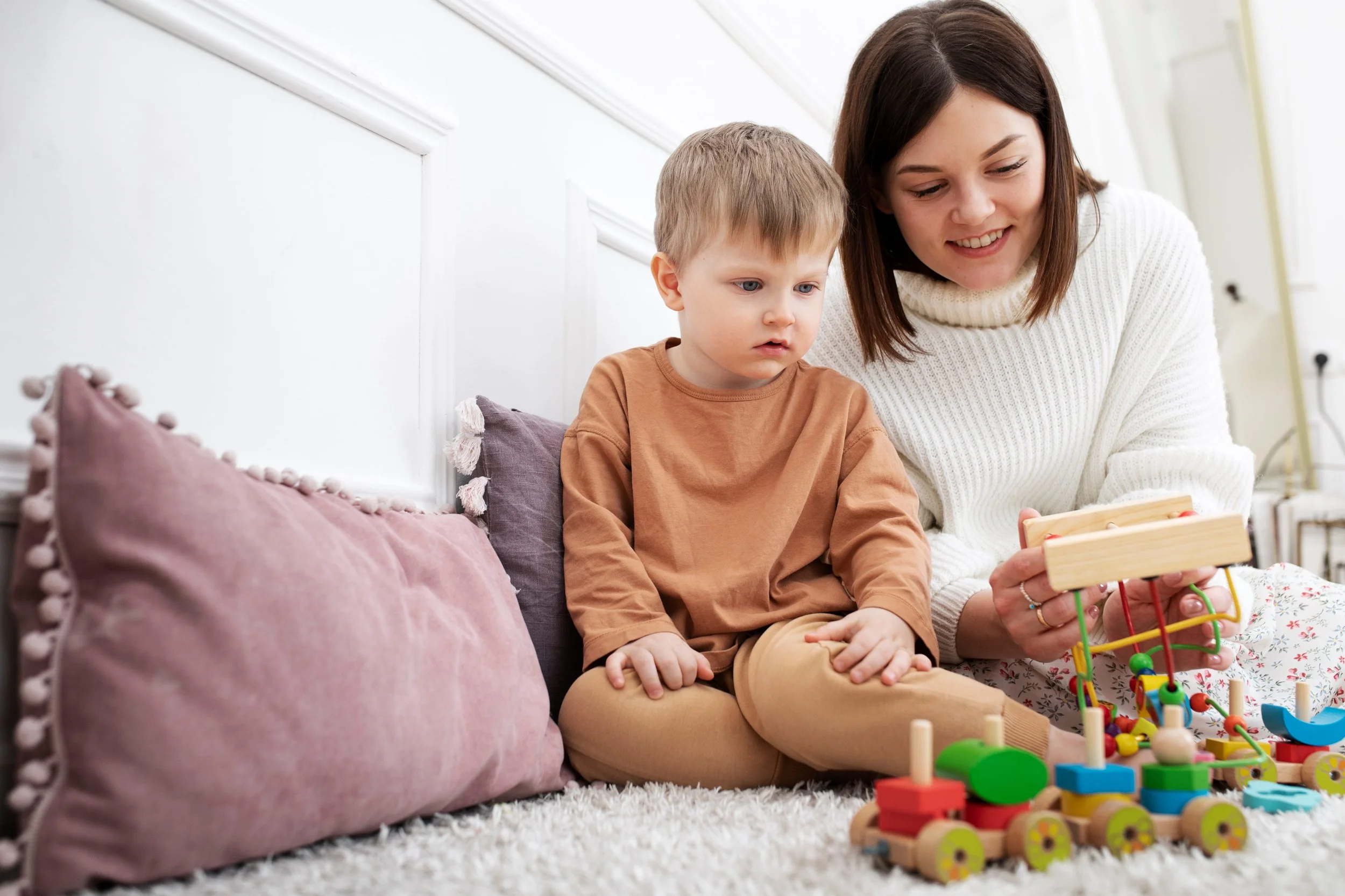 Nanny playing on the floor with little boy