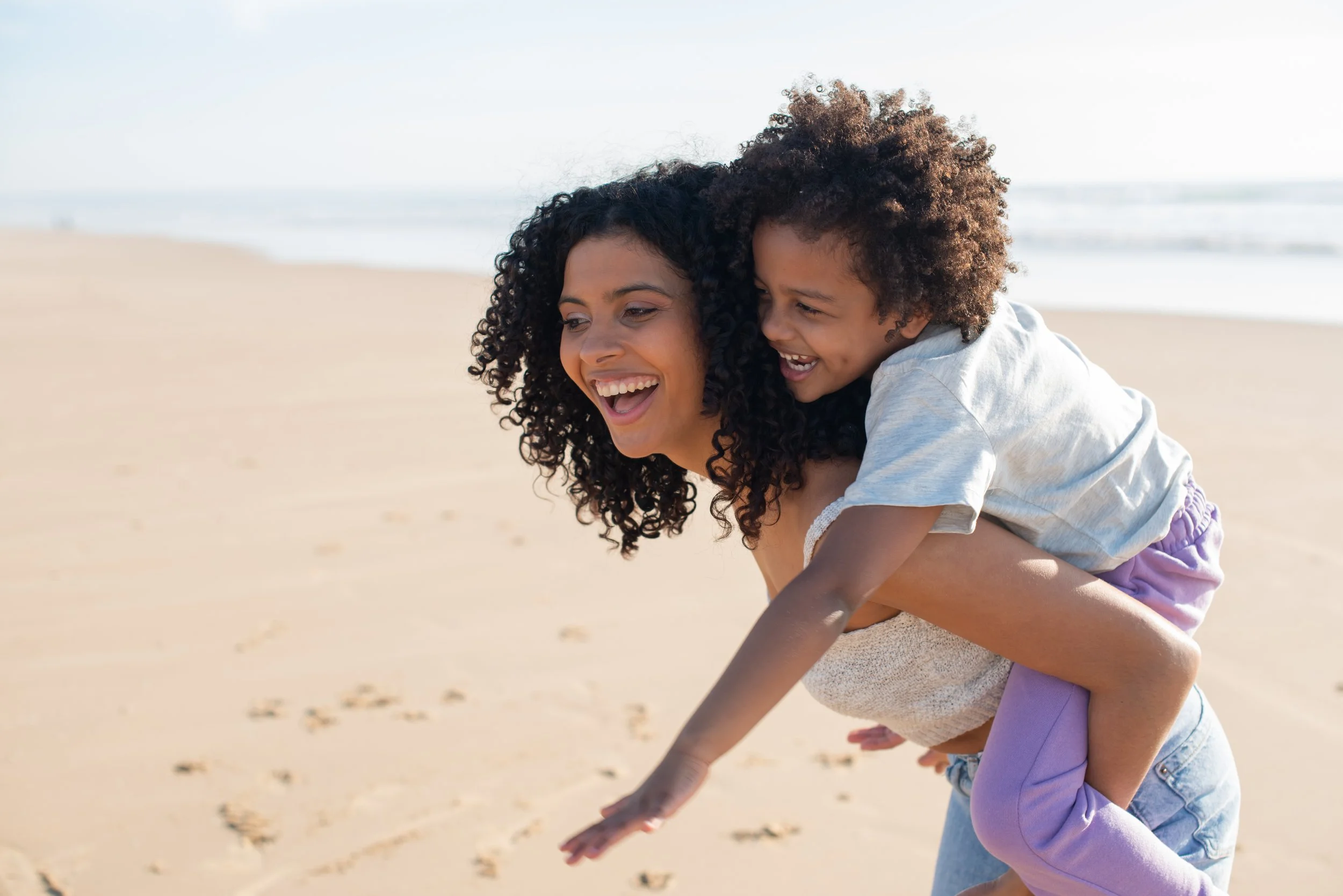 Babysitter and child playing on the beach
