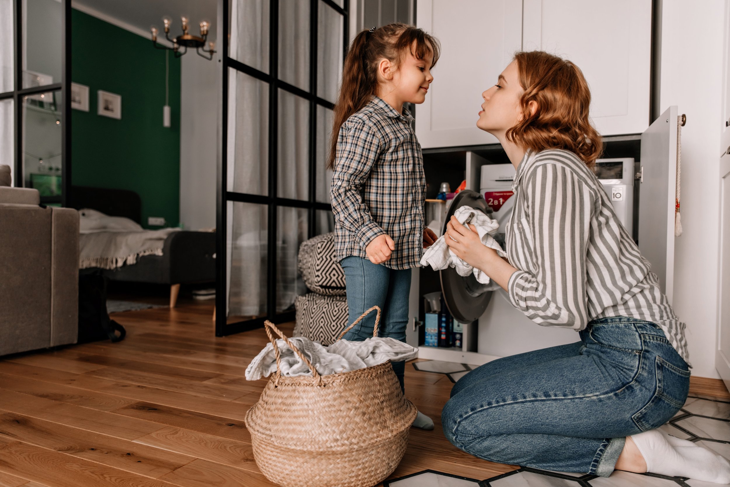 Nanny doing laundry with little girl