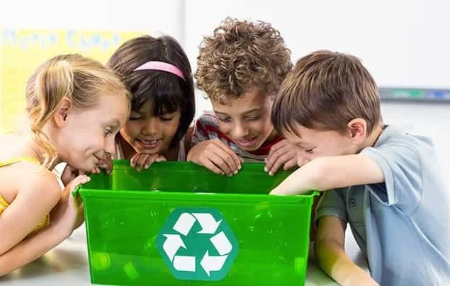 Kids looking into a recycling bin