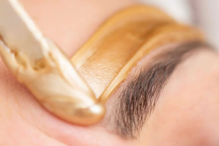 Caronlab wax being applied for a clean brow line
